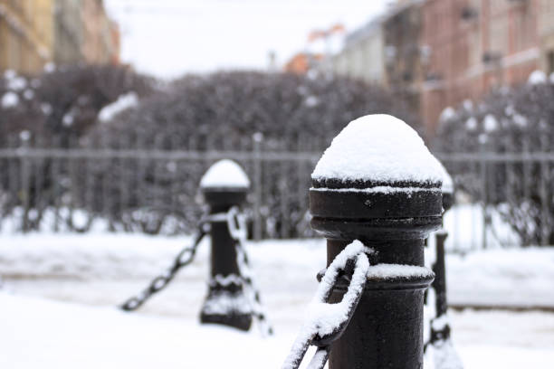 istock Cast iron fence posts with chains, covered with snow 1303654080