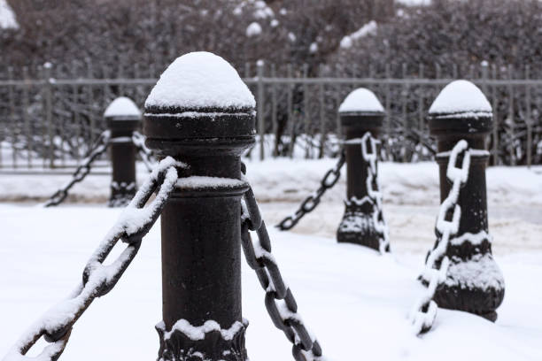 istock Cast iron fence posts with chains, covered with snow 1303654162
