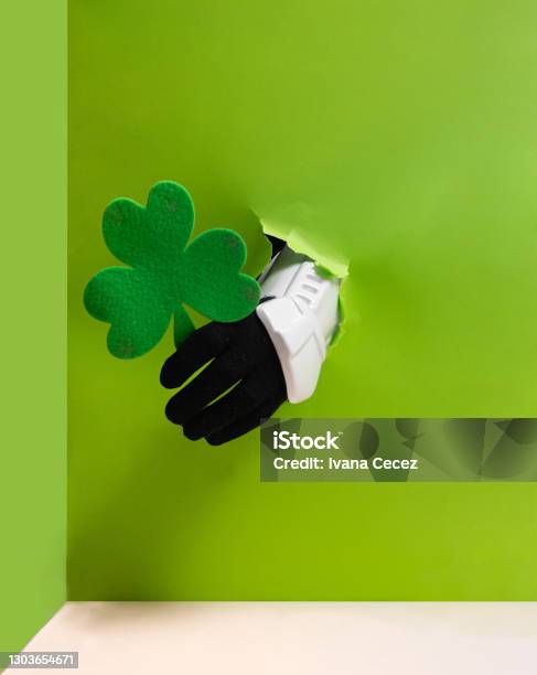 Storm Trooper Hand Is Holding Green Clover From Bright Green Wall Background Stock Photo - Download Image Now