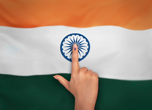female Indian Voter Hand with voting sign or ink pointing vote for India on india flag background commission of India
