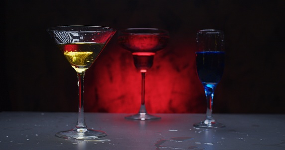 Drinks in various drinking glasses against the red and black background