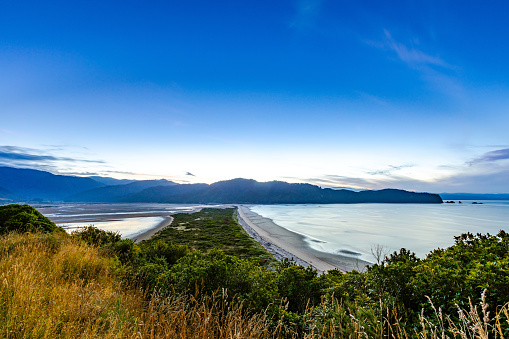 In this January 2021 dusk image, Wainui Inlet (left) and Wainui Bay (right) are seen from the Abel Tasman Coast Track in Abel Tasman National Park, New Zealand.