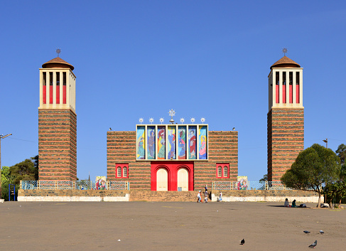 Asmara, Eritrea: Saint Mary / Enda Mariam Coptic Orthodox Cathedral, built in 1920 and modified in 1938, rationalist / modernist style by architect Ernesto Gallo and civil engineer Odoardo Cavagnari - designed with a main hall and two free-standing bell towers - alternate red layers of brick and stone, evoking the layers of wood and stone of Aksumite architecture, 'monkey heads' technique - Arbate Asmara Street (former Via Molise at Largo Somalia) - Eritrean Orthodox Tewahedo Church - Asmera, a Modernist City of Africa - UNESCO World Heritage Site.