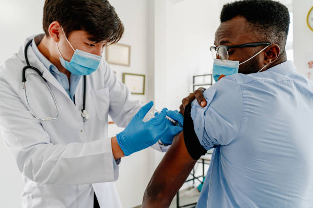 istock young  man taking a vaccine from his doctor 1303658410