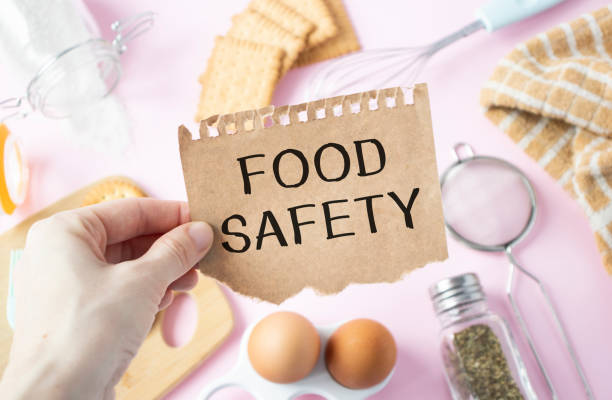 the girl holds a card with the text food safety. - food safety imagens e fotografias de stock