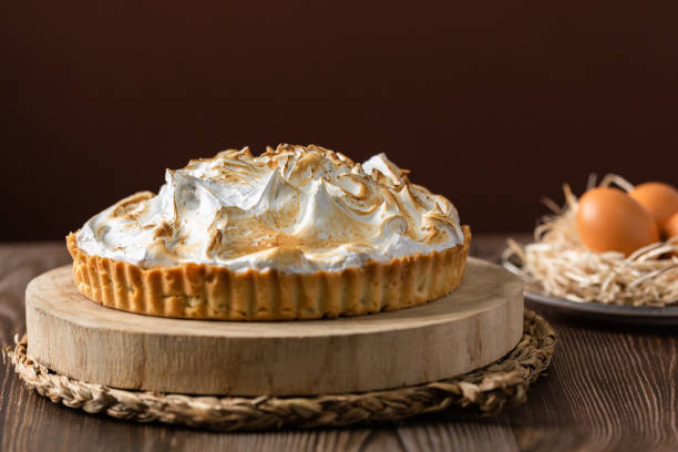 istock Lemon pie on top of log and wooden table. front view 1303660204