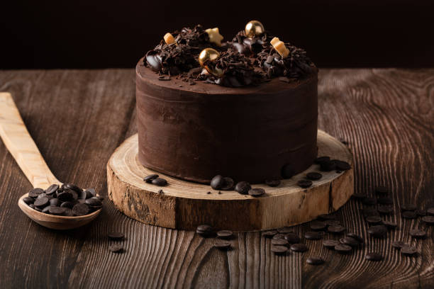 istock front view of chocolate cake, with chocolate chips, spoon and wooden table. 1303660218
