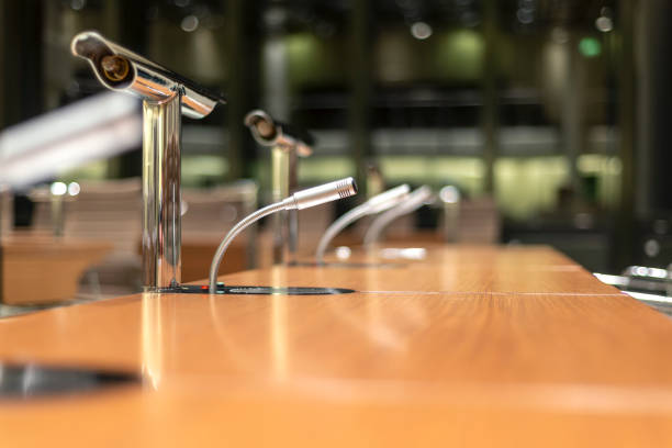 istock Isolated microphone and audio equipment on a table in the middle with blurred foreground and background, much copy space 1303661024
