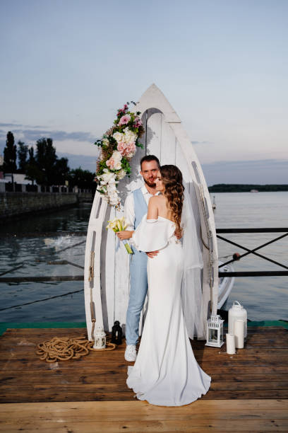 istock beautiful wedding ceremony by water on dock. bride and groom. 1303661223