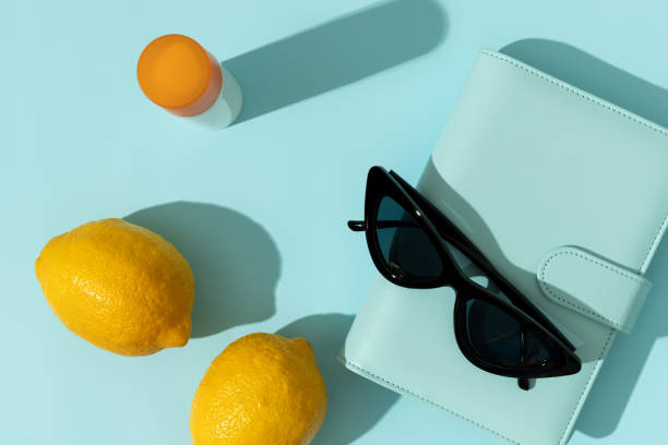istock Bottle of sunscreen and notepad with deep shadows on blue background 1303661267