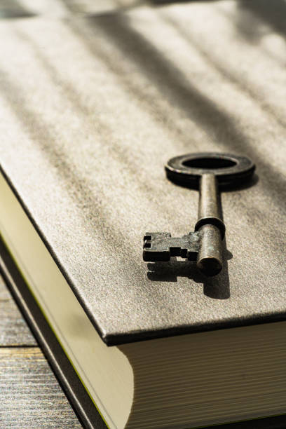 istock Vintage key and hardback book on wooden table 1303661356