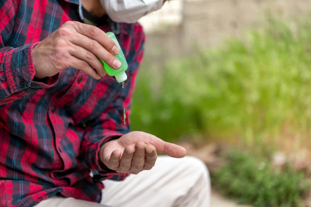 istock Businessman with a Protective Mask is Using Disinfection Gel to Wash his Hands to Avoid Coronavirus. 1303661547