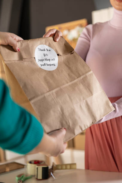 istock Giving customer her care package with ''thank you'' label 1303662466