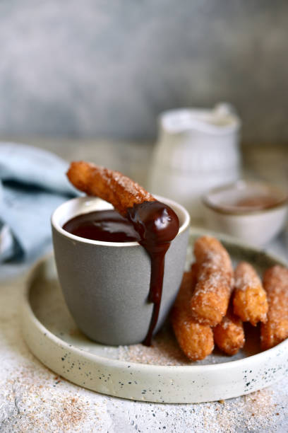 istock Traditional spanish dessert churros - fried choux pastry with chocolate sauce 1303662556