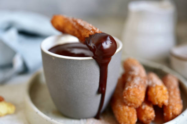 istock Traditional spanish dessert churros - fried choux pastry with chocolate sauce 1303662631