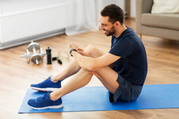 istock smiling man with fitness tracker exercising at home 1303662769