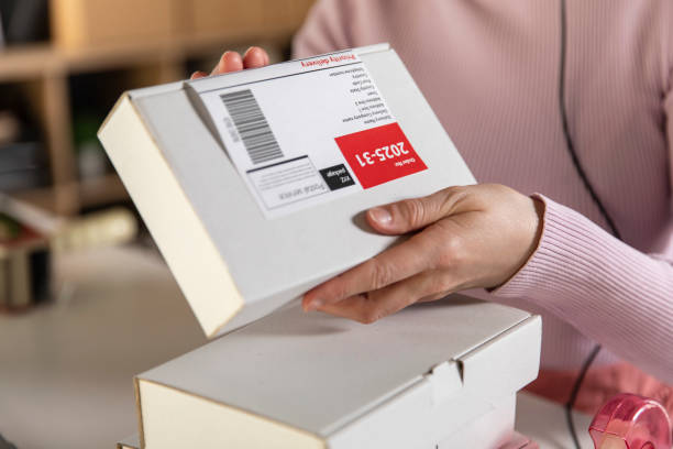 istock Unrecognizable woman applying label on a package 1303663015