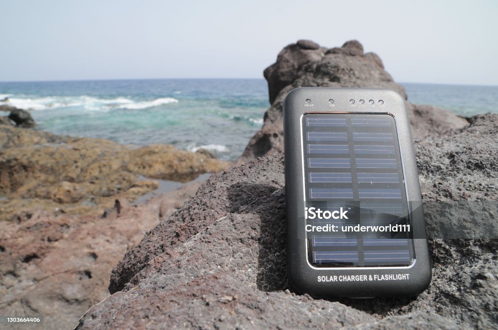 Solar Panel - energy on the beach Portable Small Solar Panel near the Atlantic Ocean Battery Stock Photo
