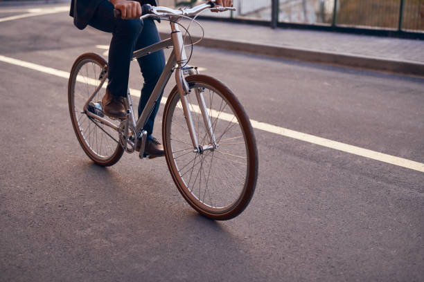 istock Crop man riding bicycle on road 1303665561