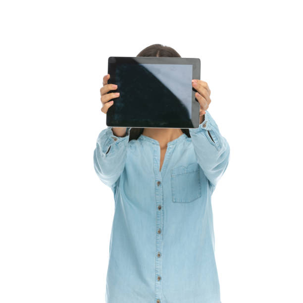 istock casual woman hiding her face behind her tablet 1303665947