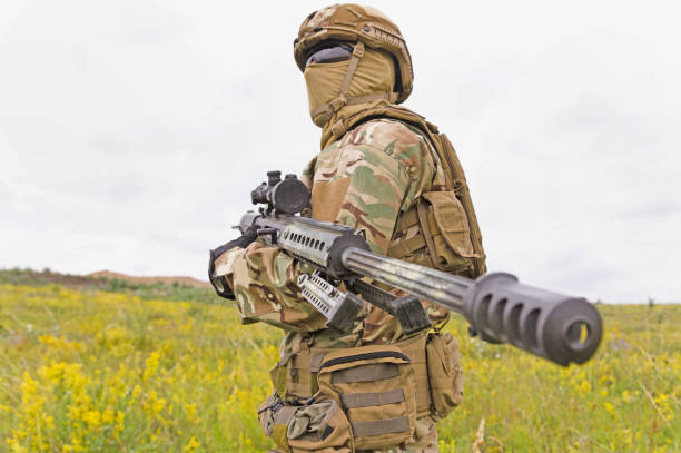 istock Special forces soldier standing in the field with rifle 1303666561