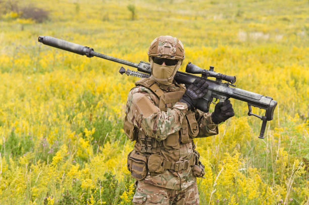 istock Soldier with sniper rifle walks across field 1303666562