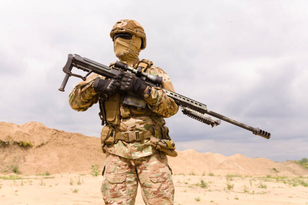 istock Soldier in camouflage holding rifle 1303666619
