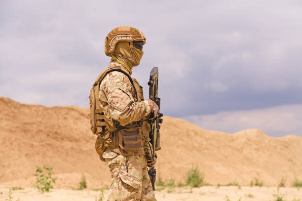 istock Soldier in camouflage with rifle close-up 1303666622