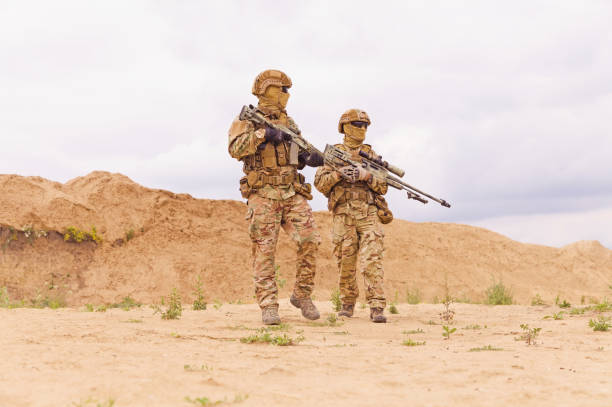 istock Two soldiers with rifles in the desert 1303666659