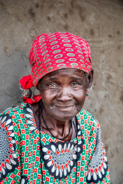 istock old african woman sitting next to the wall 1303666751