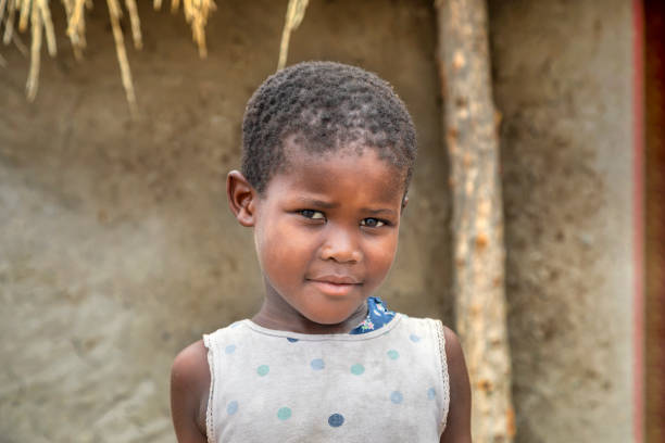 istock Small African girl standing in the yard 1303666775