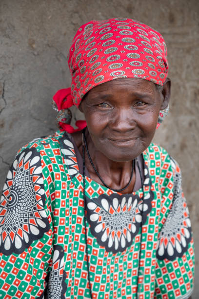 istock old african woman sitting next to the wall 1303666955