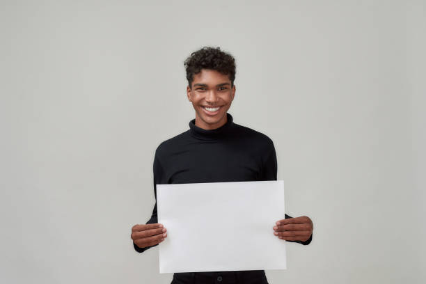 istock Young african american man holding blank poster 1303668419