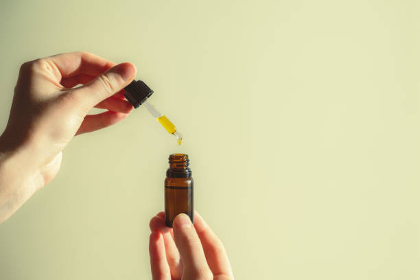 istock Dropper of cbd or thd oil in human hands. 1303671776