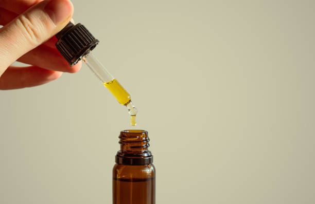 istock Dropper of cbd or thd oil in human hands. 1303671804