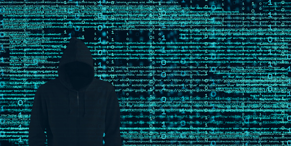 Hacker in black hood Shows the extraction through binary. Stand in front of a code background with binary streams and information security terms  cyber security concept