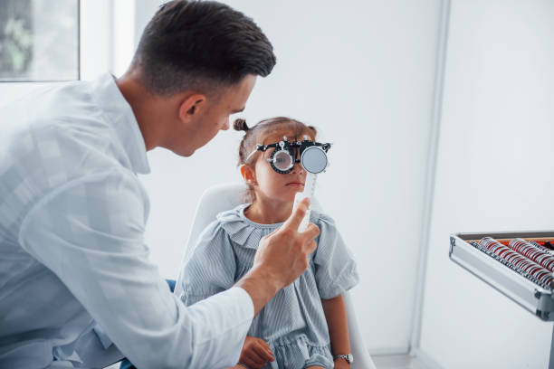 istock Testing vision. Young ophthalmologist is with little female visitor in the clinic 1303674628
