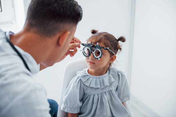 istock Testing vision. Young ophthalmologist is with little female visitor in the clinic 1303674630
