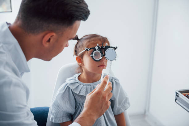 istock Testing vision. Young ophthalmologist is with little female visitor in the clinic 1303674713