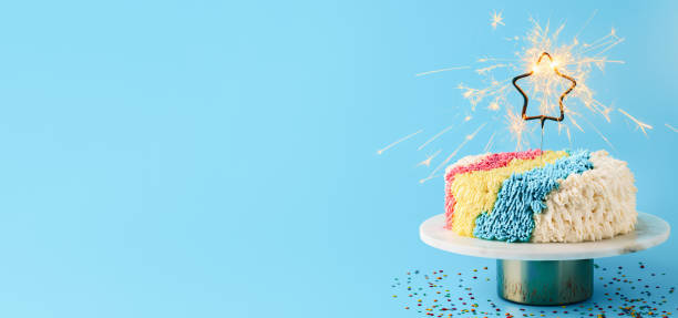 istock Shag cake with sparkler on blue, copy space 1303674778