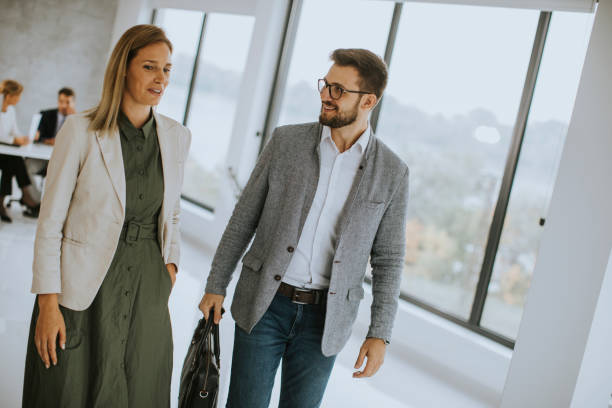 istock Young business couple walking together at office space 1303675923