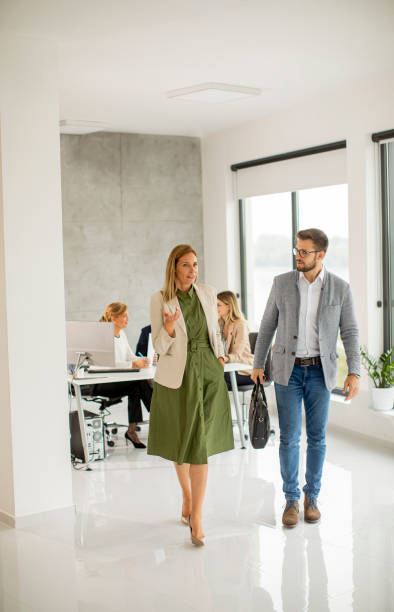 istock Young business couple walking together at office space 1303675924
