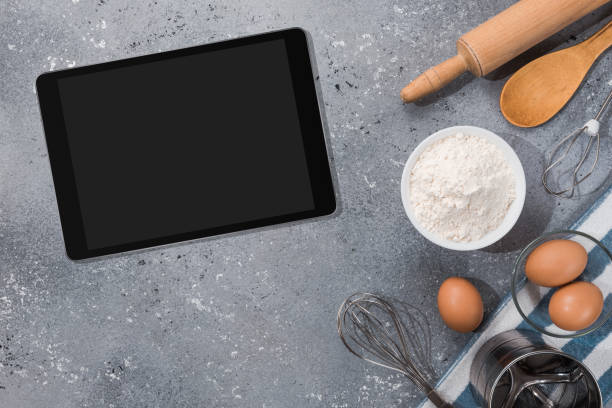 istock Ingredients, tools for baking and tablet with blank screen and place for text or image on gray table. recipe, cookbook, cooking courses online template 1303676106