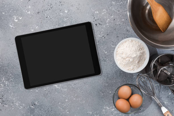 istock Ingredients, tools for baking and tablet with blank screen and place for text or image on gray table. recipe, cookbook, cooking courses online template 1303676130