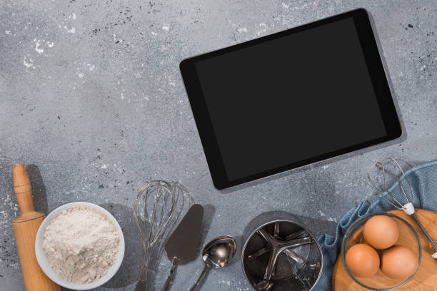 istock Ingredients, tools for baking and tablet with blank screen and place for text or image on gray table. recipe, cookbook, cooking courses online template 1303676141