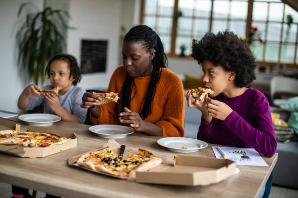 istock Young family enjoying pizza for lunch at home 1303676414