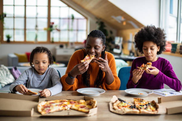 istock Young family sharing pizza for lunch at home 1303676473