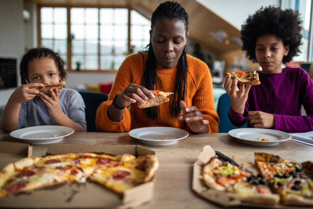 istock Family eating pizza together at home 1303676762