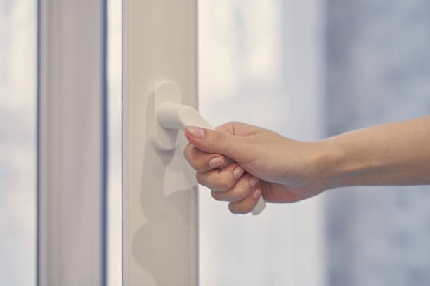 istock Female hand opens and closes plastic window. Close up. 1303678473