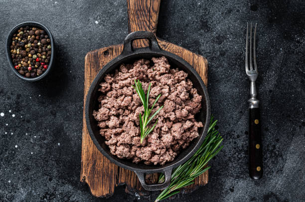 istock Fried mince beef meat in a pan for cooking pasta. Black background. Top view 1303679933